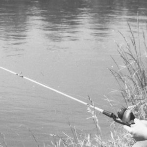 00-00-0000 Boy sitting at pond with fishing pole. Photo by Robert Mills