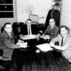 00-00-0000 Four men sitting around a table. Photo by Robert Mills