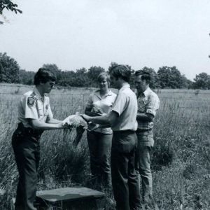 00-00-0000 Game official holding pheasant as 3 other people look on -website