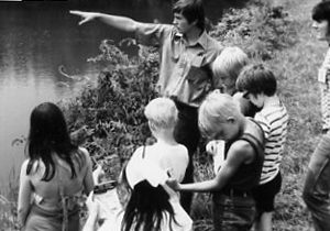 00-00-0000 Leader pointing to somehting in pond. Group of boys and girls look on. Photo by Robert Mills