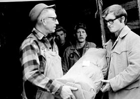 00-00-0000 Man handling bundle of trees to another man. Photo by Robert Mills