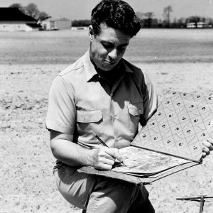 00-00-0000 Man kneeling in field writing on a chart. Photo by Robert Mills