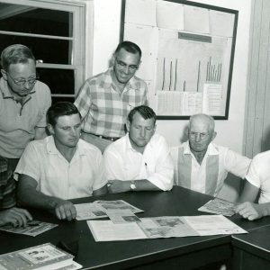 00-00-0000 Seven men at table examining documents#1-Website