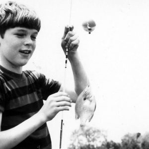 Boy with fishing pole & a fish attached.Photo by Robert Mills