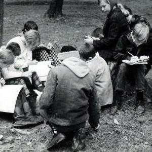 Group of students seated on ground taking notes. Photo by Robert Mills