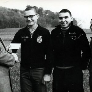 Land Judging unidentified man giving award to 3 young people #2-Website