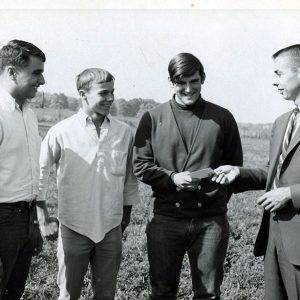 Land Judging unidentified man giving award to 3 young people#3-Website