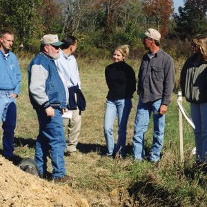 Land Judging. Ten men and women around pile of soil-Website