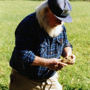 Land Judging.Man examining piece of soil-Website