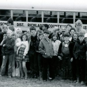 Large gourp of boys and girls & 1 adult standing in front of Crestview school bus on a farm-0001