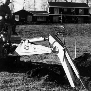 Man operating a backhoe. House under construction in back ground .Photo by Robert Mills