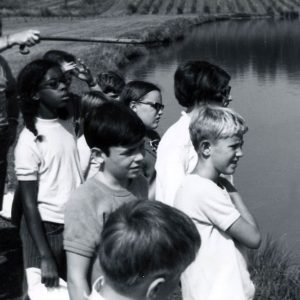 Man pointing to lake as group of students look on. Photo by Robert Mills