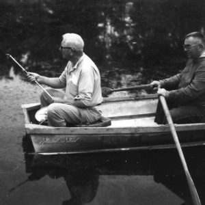 Two men in row boat-one fishing, one rowing .Photo by Robert Mills