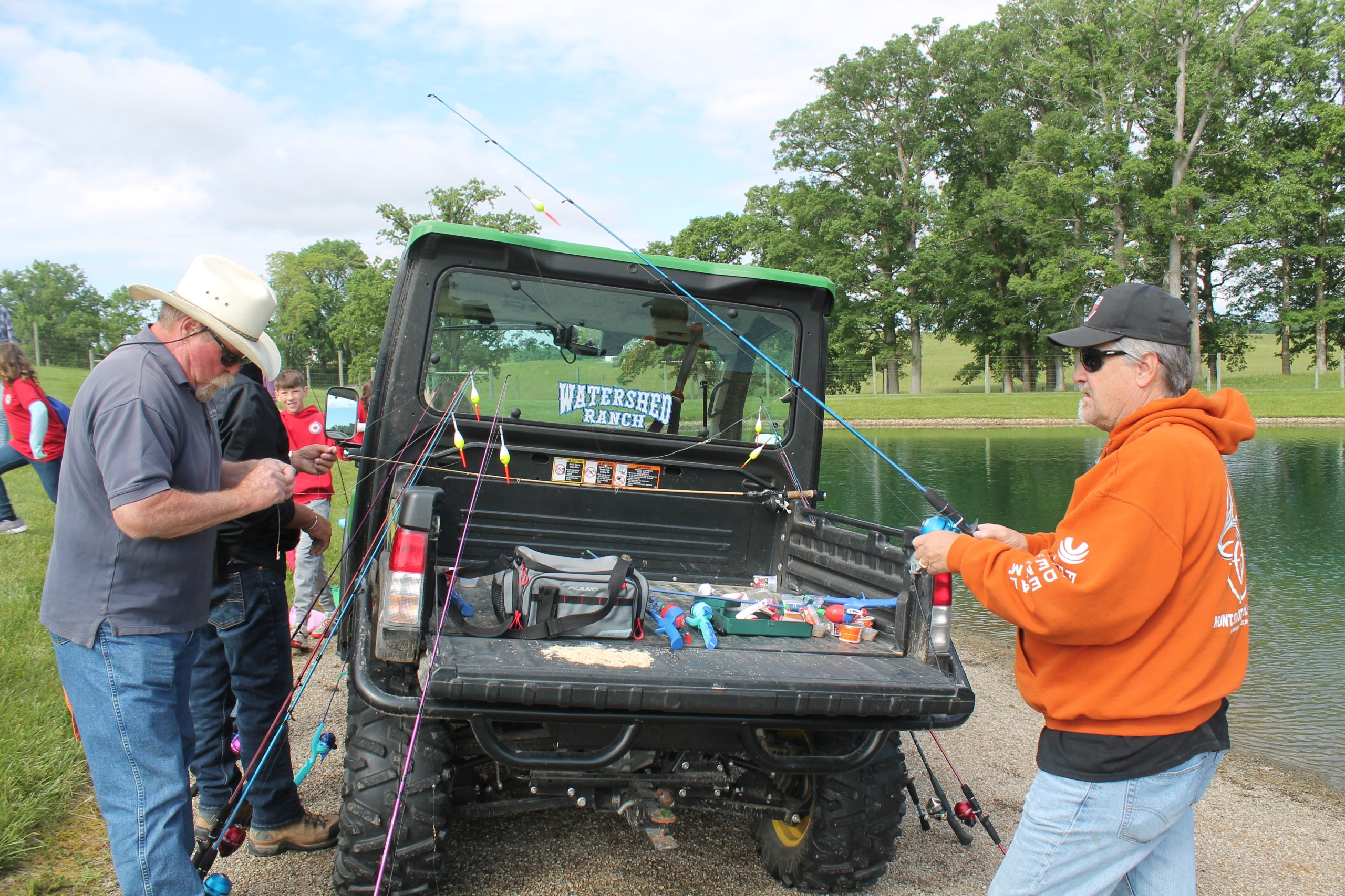 Neil McKown (left) and a friend help bait fishing lines for students.