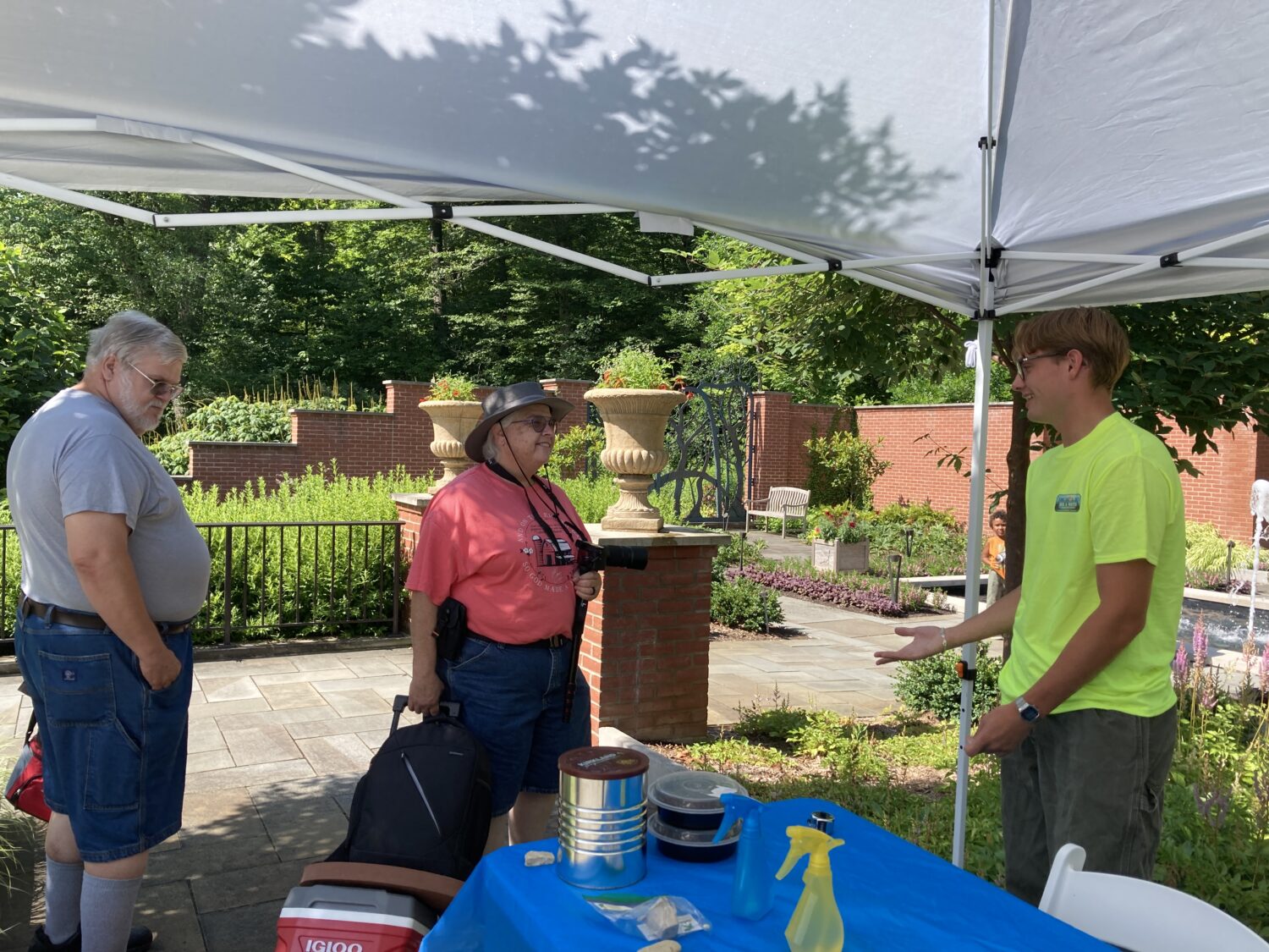 Intern speaking to two guests at our vendor booth at Kingwood Center 