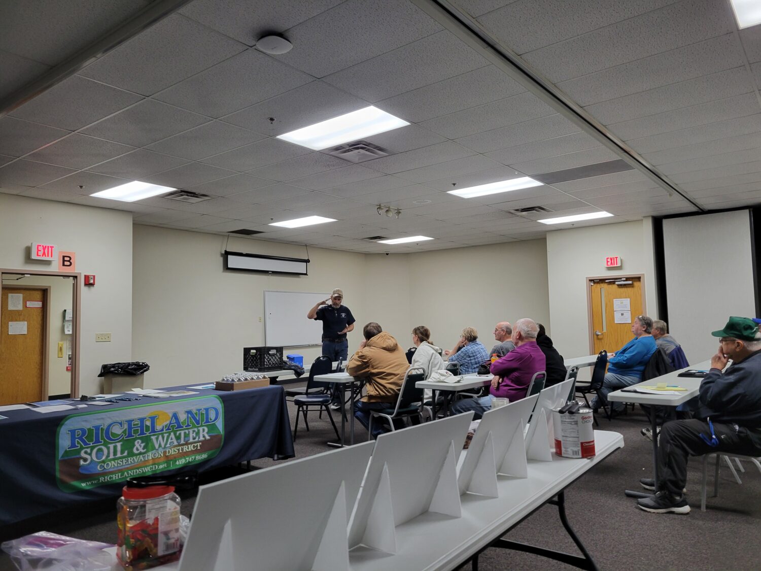 Steve Fender speaking to a group of seated people at the pond clinic. 