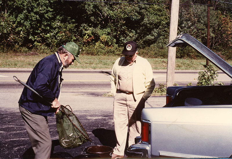 Two men putting fish in bucket
Photo ID#: S55