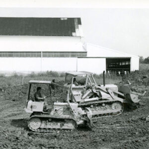 00_00_0000_Two_pieces_of_equipment_in_front_of_barn_moving_either_dirt_or_waste_website-552