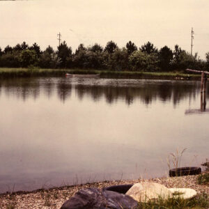 00_00_0000_Unidentified_pond_with_canoe_on_it_and_pines_in_background_website-4243