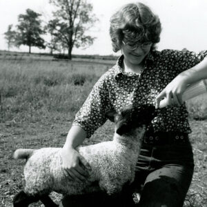 06_03_1973_Leesa_Rader__daughter_of_Mr.___Mrs._Delvin_Rader__bottle_feeds_a_lamb_at_the_family_farm_website-807