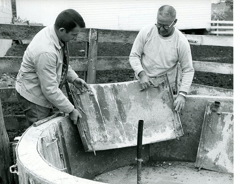 October 9, 1967
Left to Right: J.P. Haip and Carl Mowry as they remove the forms from their poured concrete 
550 gallon spring development tank at the Carl Mowry Farm
Photo ID#: A690