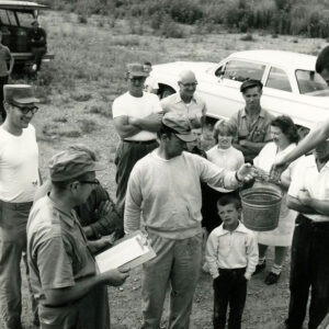Receiving_fish_at_Bellville_are_Avery_Adams_his_son__and_father_Roger_Adams_with_others_looking_on_website-3800