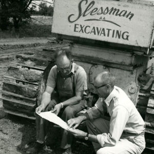 Two_men_examining_plans_in_front_of_excavator_website-2853